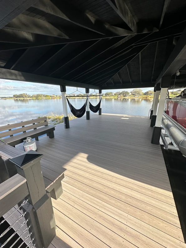 Spacious covered dock with bench seating and hammocks overlooking the lake.