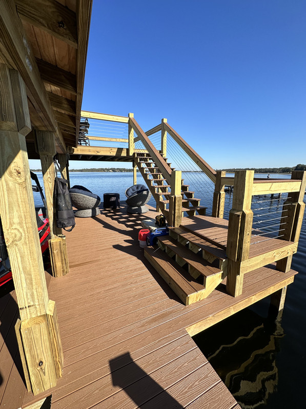 Partially covered dock with wooden stairs leading to upper seating area.